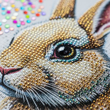 Détail des diamants brillants d'une peinture diamant lapin.